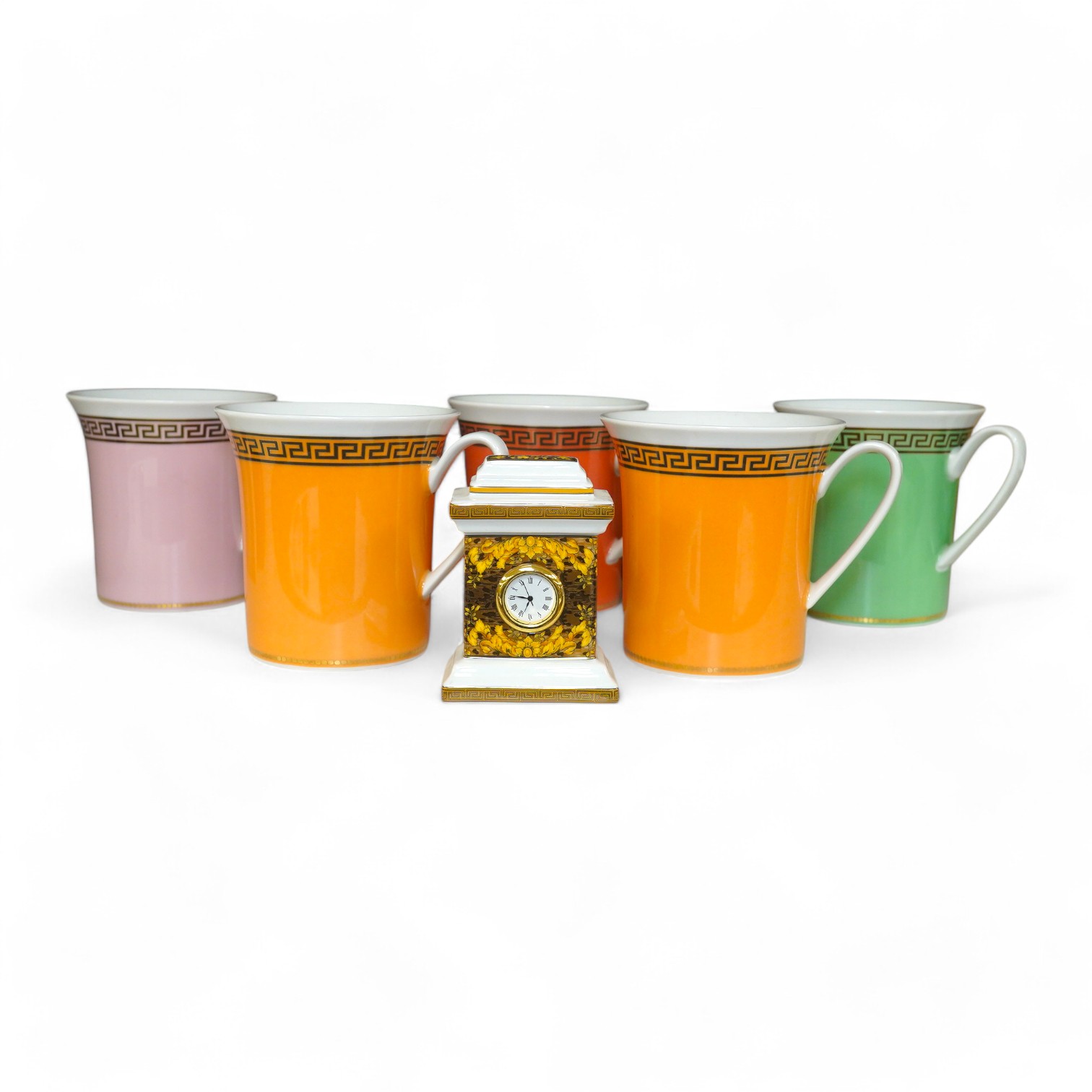 Five boxed Rosenthal for Versace mugs in various colours with Greek key pattern decoration together with a boxed miniature timepiece, 8.5cm high (6). Condition - good.